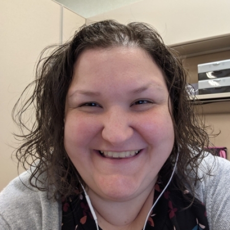 young Caucasian woman with shoulder length curly hair, smiling